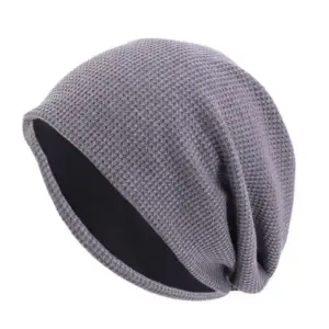 Graue Slouch-Beanie mit Waffelstruktur und schwarzem Innenfutter, frei stehend fotografiert