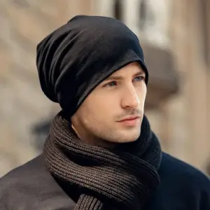 00-19 Schwarze lockere Beanie, getragen von einem Mann mit Schal vor Altstadtkulisse