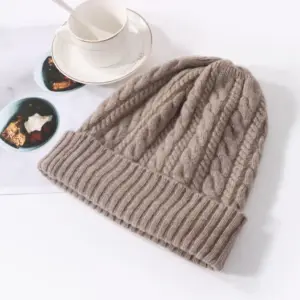 Zopfmuster-Mütze mit breitem Umschlag auf weißem Tisch