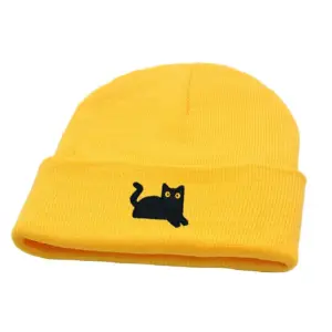 Gelbe Strickmütze mit gesticktem schwarzem Katzenmotiv und breitem Umschlag auf Weiß