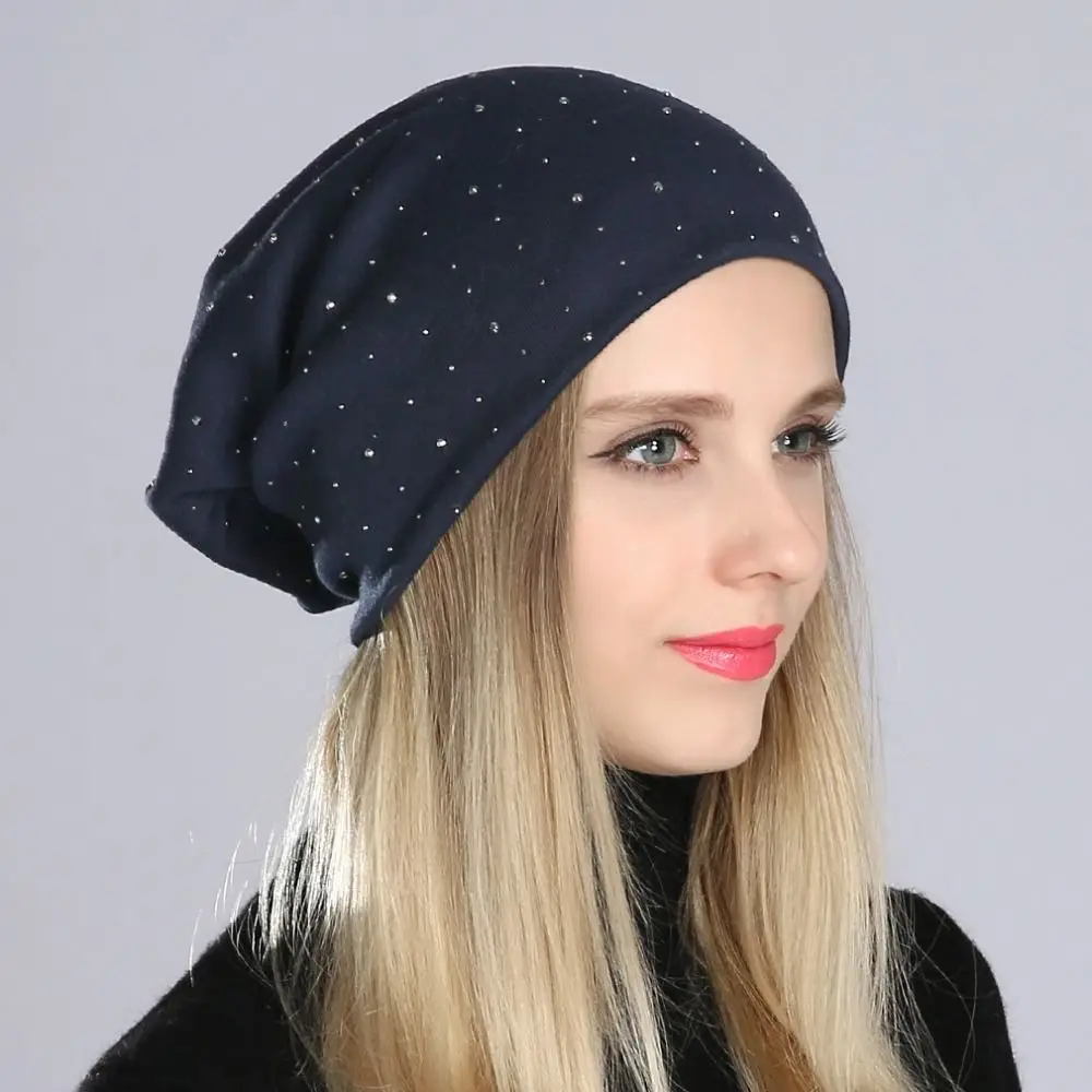 Frau trägt dunkelblaue Slouch-Beanie mit kleinen glitzernden Strasssteinen, seitlich fotografiert