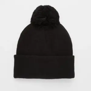 Schwarze Strickmütze mit breitem Umschlag und großem schwarzem Bommel auf hellem Hintergrund