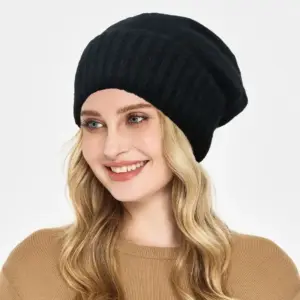 Schwarze weite Strickmütze mit Rippenbündchen, getragen von lächelnder Frau mit blonden Haaren