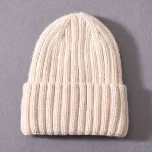 Cremefarbene grob gerippte Beanie mit breitem Umschlag auf grauem Untergrund