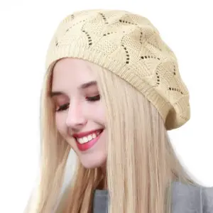 Beige gestrickte Baskenmütze mit Lochmuster, getragen von einer blonden Frau